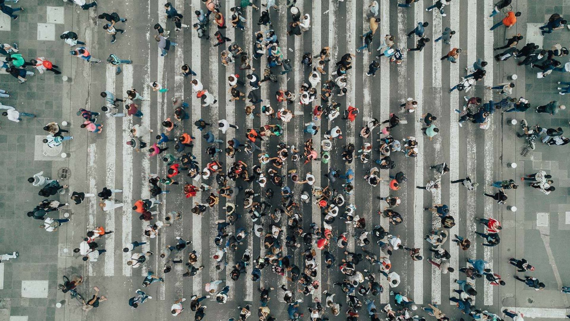 Aeriel view of crowds of people walking across a pedestrian crossing