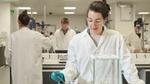 A woman scientist at Unilever’s Port Sunlight fragrance R&D hub testing perfumes in the lab. She wears goggles and a white coat.