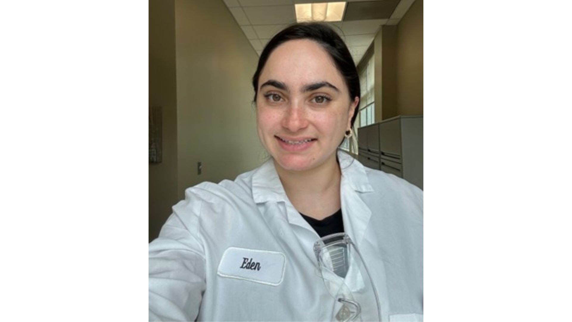 A photo of a scientist who worked on the Vaseline Verified campaign. A  white woman with brown hair, in a lab coat.