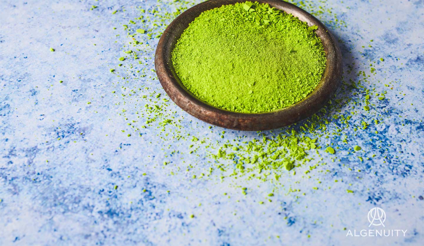 A small bowl of lime green microalgae powder.