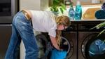 Woman removing laundry from a Samsung washing machine.