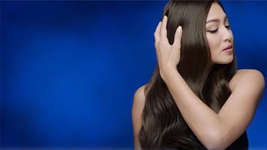 Nadine Lustre's hair is draped over her shoulders, on the left side of the frame. She is stroking it gently.