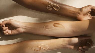 Three forearms of different skin tones displayed horizontally, each with two swatches of Vaseline skincare product in shades matching the skin tone.
