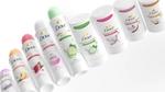 A line-up of Dove spray and stick deodorants with pink, light green, purple and orange lids.