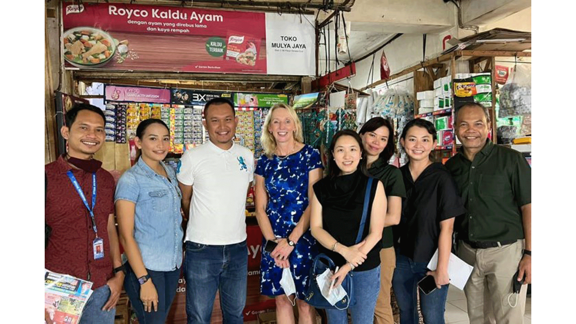 Hanneke Faber, Kristine Go and other Nutrition leaders stand in front of a mom and pop store 