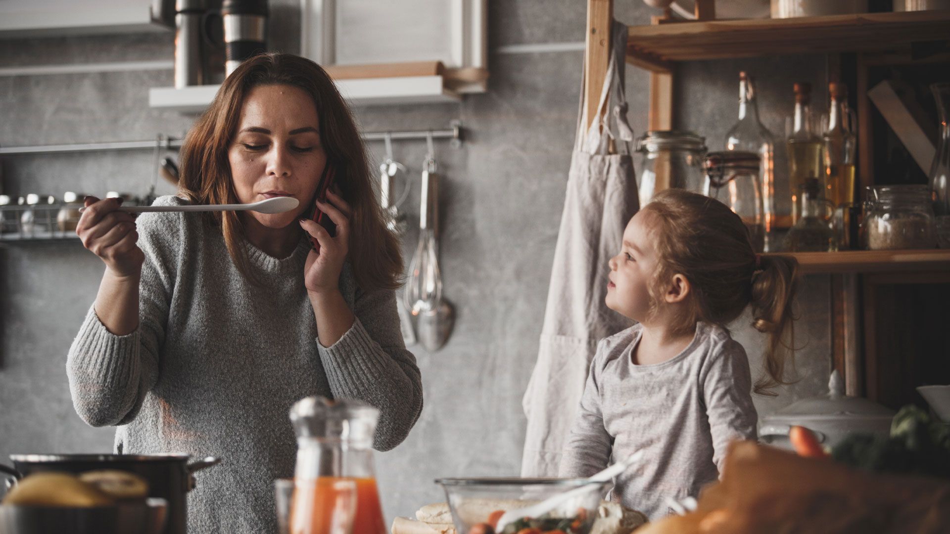 A stand at Gulfood exhibition with shelves of food and branded posters