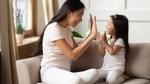 A mother and daughter high fiving each other